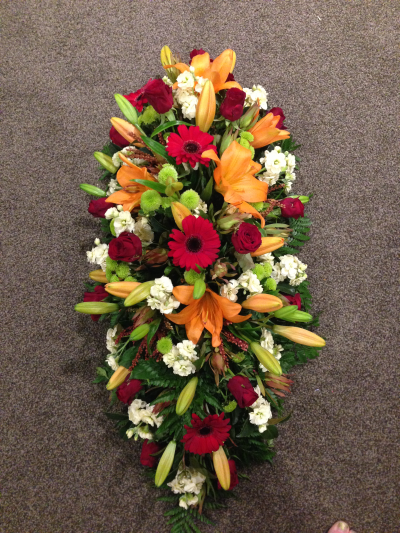 Autumn Glow Spray - A warm and vibrant funeral tribute, beautifully arranged to celebrate a life filled with love and treasured memories.