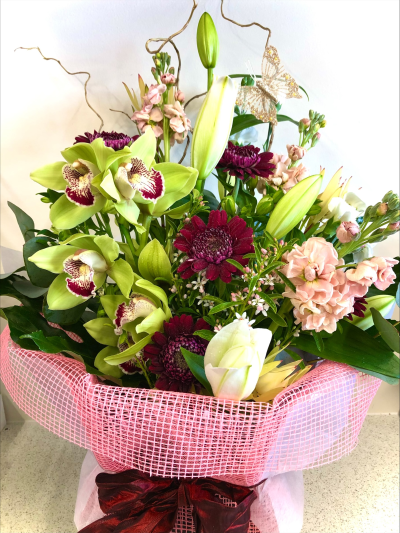 Orchid Charm - A luxurious contemporary arrangement featuring elegant textures and rich colours, beautifully presented to make a truly memorable gift.